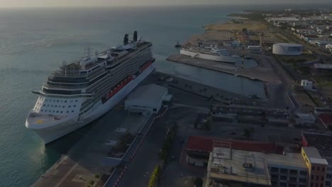 Aerial-view-of-the-big-cruise-ship-in-dock-next-to-a-smaller-ship-with-a-blue-skies