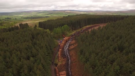 Forestry-and-logging-operations-taking-place-in-the-highlands-of-Scotland-using-large-industrial-machinery,-ships-and-trucks