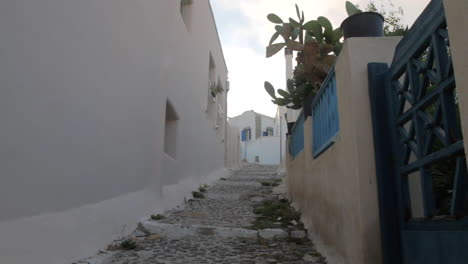 A-man-is-walking-up-an-alley-in-a-Greek-cycladic-village