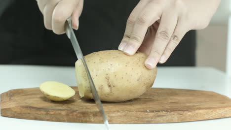 Frau-Schneidet-Kartoffeln-Auf-Einem-Schneidebrett