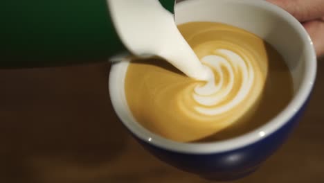 Professional-female-barista-makes-rosetta-in-cappuccino---close-up