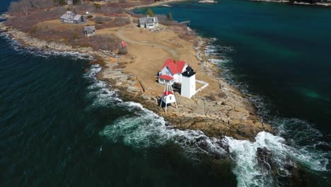 Orbiting-around-Hendricks-Head-Lighthouse-with-waves-crashing-on-penisula-AERIAL