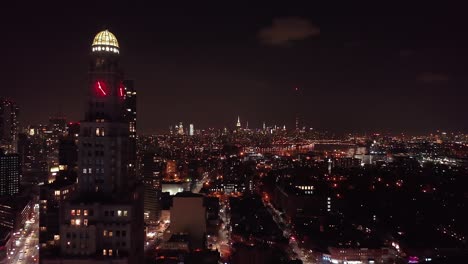 Drone-footage-of-the-Brooklyn-and-Manhattan-city-skyline-at-night,-taken-from-Brooklyn-New-York