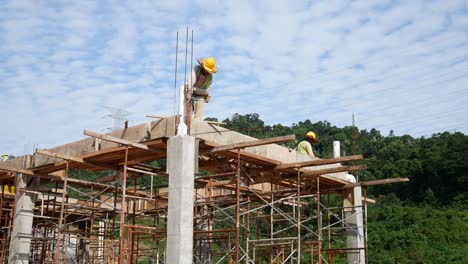 Bauarbeiter,-Die-Auf-Der-Baustelle-Holzschalungen-Und-Regenwasserrohre-Installieren
