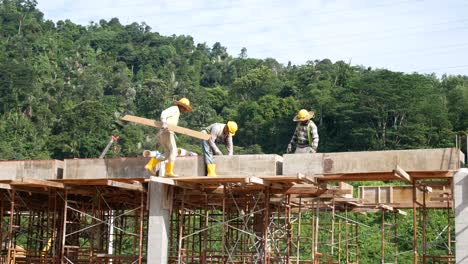 Construction-workers-installing-timber-form-works-and-rain-water-down-pipes-at-the-construction-site