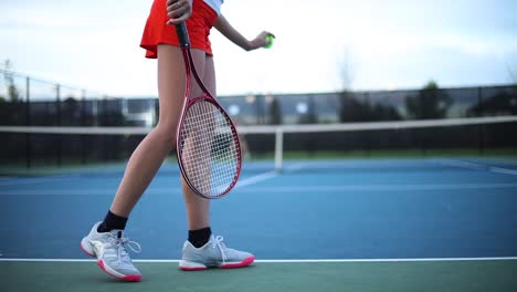 Eine-Frau-Lässt-Einen-Ball-Hüpfen-Und-Springt,-Um-Sich-Aufzuwärmen,-Bevor-Sie-Ihr-Tennismatch-Beginnt