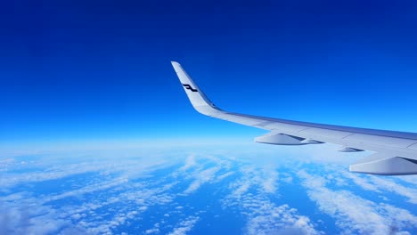 Finnair-Airplane-wing,-Cirrus-uncinus-blue-sky,-vacation-mode