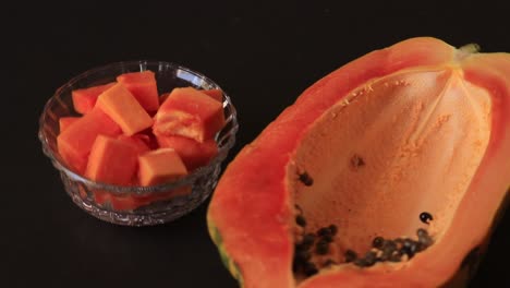 papaya-slice-and-papaya-juice-on-green-leaf-and-black-background,-healthy-and-diet-fruit