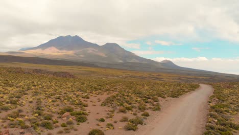 Toma-Cinematográfica-Aérea-Que-Revela-Un-Hermoso-Paisaje-Siguiendo-Un-Camino-De-Tierra-En-El-Desierto-De-Atacama,-Chile,-Sudamérica