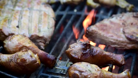 ribs-and-spice-rubbed-chicken-legs-with-grill-marks-on-outdoor-grill-closeup-showing-flames-and-smoke-with-copy-space