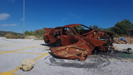 drone-footage-of-burnt-car,-arson,-destroyed,-totaled,-car-insurance,-rusty-wreck
