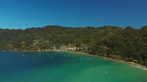 Man-o-War-Bay-aerial-footage-with-Pirate's-Bay-in-the-background-in-the-fishing-village-of-Charlottevile,-Tobago