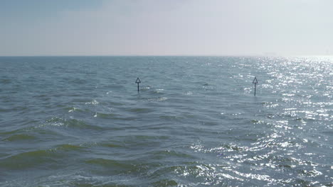 Slow-motion-water-around-two-sea-markers-in-the-water-of-the-coast-of-the-UK