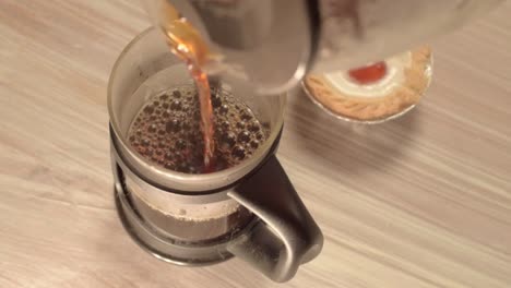 Gießen-Sie-Frischen-Kaffee-In-Eine-Kanne-Mit-Kirschkuchen