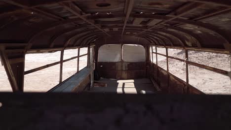Peeking-inside-an-abandoned-bus-in-Atacama-desert,-South-America,-Chile