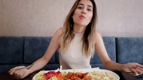 Slow-motion:Beautiful-young-girl-eats-chicken-food-with-a-big-enjoy-in-a-restaurant-or-cafe-while-sitting