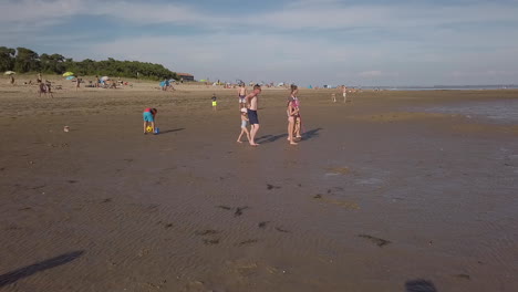 French-family-walking-at-low-tide-on-the-sand-of-Gatseau-beach-to-get-shells