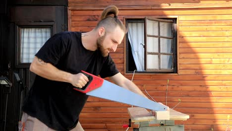Man-sawing-wood-with-hand-saw
