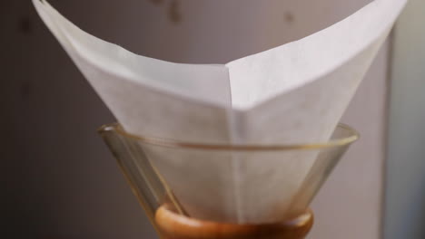 Pouring-coffee-into-the-filter-and-glass-press-for-french-press-coffee-preparation-caught-in-front-as-crushed-coffee-falls-into-the-filter-in-slow-motion-capture-at-120-FPS