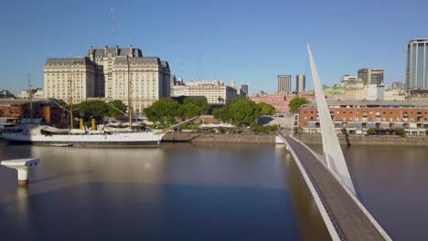 Aerial-of-Woman’s-bridge-and-Sarmiento-Frigate-in-Puerto-Madero,-Buenos-Aires