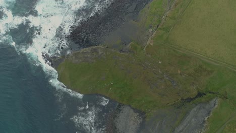 Luftaufnahme-Aus-Der-Vogelperspektive-Der-Epischen,-Aufregenden-Landschaft-Der-Klippen-Von-Moher,-Während-Wellen-Auf-Den-Felsigen-Küstenstrand-Irlands-Rollen