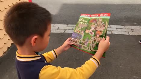 Boy-excitedly-looking-through-a-map-guide-of-Edaville-Family-Theme-Park-Thomas-Land