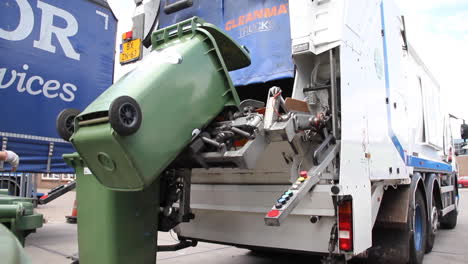 Trash-bin-being-emptied-in-garbage-truck-and-collector-emptying-new-bin