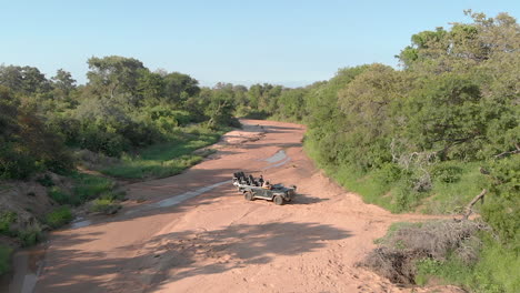 Aerial-shot-of-safari-vehicle-crossing-sandy-riverbed-at-Timbavati-Game-Reserve