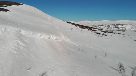 Paisaje-Montañoso-Invernal-Con-Ventisquero-Congelado-Que-Sobresale-Del-Acantilado,-Mini-Avalancha