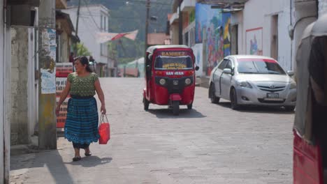 Drei-Rote-Guatemaltekische-Tuktuks-Fahren-In-Den-Straßen-Von-San-Juan-Vorbei