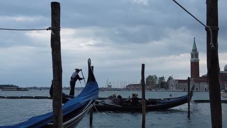 Tourists-on-Venetian-gondolas-parked-at-Venice-canal-dock