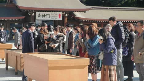 People-praying-at-the-Meiji-Jingu-shrine-in-Shibuya,-Tokyo,-Japan