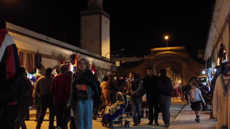 Vista-De-La-Calle-De-Hombres-Y-Mujeres-Locales-Comprando-En-Essaouira,-Marruecos-Por-La-Noche