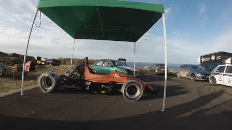 New-Racing-Car-Under-The-Green-Tent-At-The-Hill-In-Imtahleb-Malta-With-Wheels-Covered-With-Plastic---Closeup-GoPro-Shot