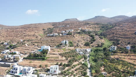 Aerial-drone-flight-towards-dry-mountain-landscape-with-few-houses-located-on-the-hill-in-Tinos,Greece