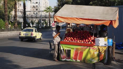 Male-apple-vendor-piling-his-fruits-on-the-side-street