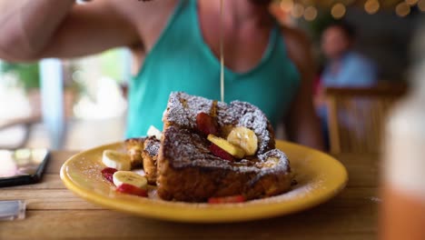 Slowmotion-shot-of-a-guy-dripping-honey-over-frenchtoast-in-a-restaurant