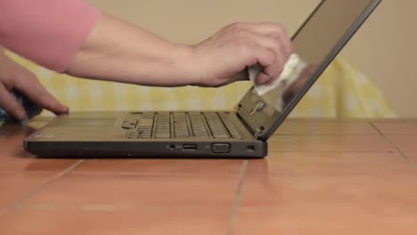 Hands-cleaning-laptop-with-cloth-medium-shot