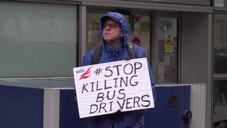A-man-holds-a-placard-saying,-â€œStop-Killing-Bus-Driversâ€-at-Workers-Memorial-Day-minute-silence-for-healthcare-deaths-held-outside-The-Royal-London-Hospital-during-the-Coronavirus-outbreak