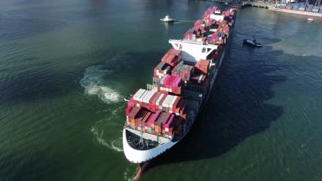 Two-Tugboats-manoeuvring-a-large-empty-Container-Ship-into-Hong-Kong-port,-Aerial-view