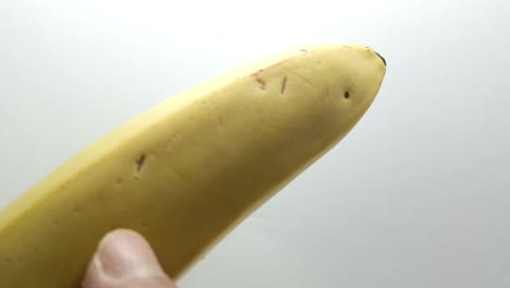 Point-finger-gently-touches-a-banana-fruit