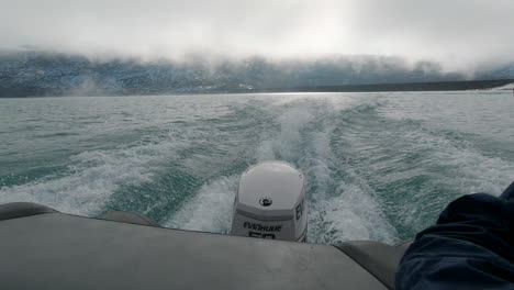 Nahaufnahme-Des-Motors-Eines-Schnellboots,-Das-über-Einen-Strahlend-Blauen-Gletschersee-Mit-Schneebedeckter-Bergkulisse-Fährt