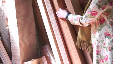 Slow-motion-view-of-Choosing-wood-for-work-in-the-carpentry-workshop-by-the-woman