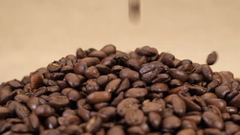 Coffee-beans-falling-on-jute-canvas-background