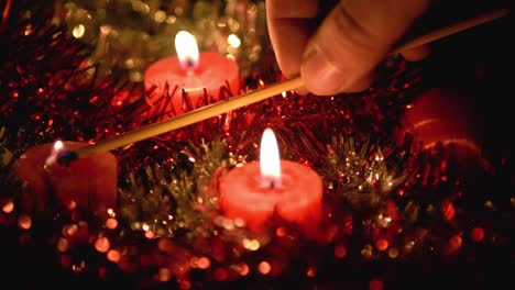 Wunderschönes-Video,-In-Dem-Kerzen-Von-Hand-Angezündet-Und-Mit-Dem-Letzten-Schlag-Gelöscht-Werden,-Funkelnde-Hintergründe-Aus-Weihnachtsdekoration