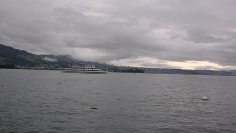 Bodensee,-Lake-Constance-on-cloudy-day,-ferry-boat-on-horizon-in-Hagnau,-Germany