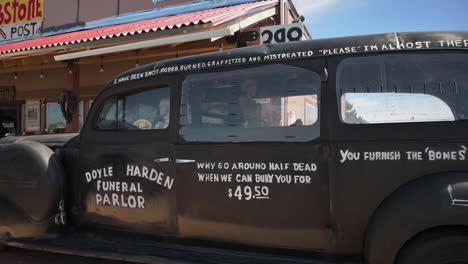 A-black,-old-style-hearse-on-display-in-Tombstone,-Arizona---wide-pan