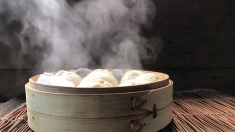 side-view-of-uncovering-lid-of-cooked-steamed-buns-showing-steam-rising