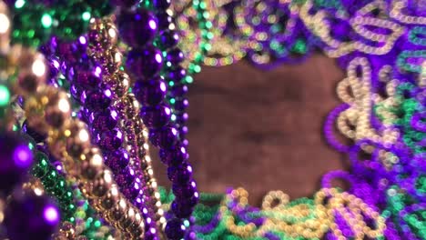 flat-lay-border-of-colorful-Mardi-Gras-beads-with-more-beads-hanging-on-side-moving-slightly