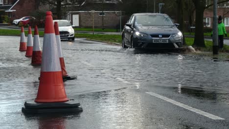 Storm-Christoph-car-driving-rainy-flooding-village-road-splashing-street-cones-towards-camera